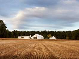 The house sits at the nexus of the land’s constituent characteristics: forests to the west, a hill to the south, and 100 acres of fields to the north and east : Photo credit © Ben Rahn / A-Frame Studio